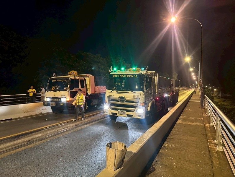 Bridge load test — heavy trucks positioned on bridge at night